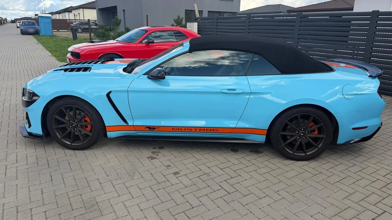 Lateral del Mustang Convertible con capota negra y franja naranja Mustang