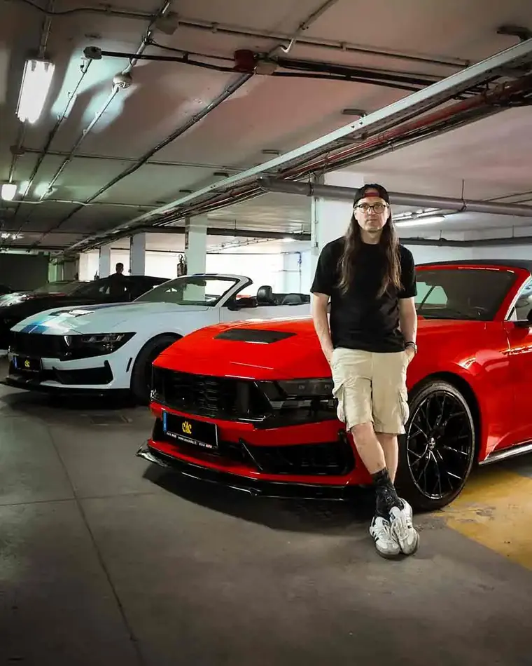 Iván Mora with Mustangs from the fleet in the garage
