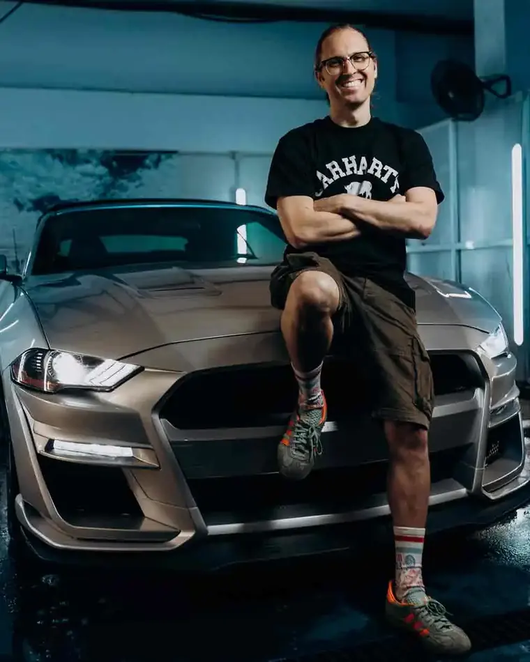 Iván Mora leaning on a Shelby from the fleet