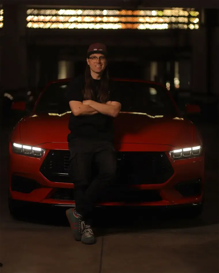 Iván Mora with a red Mustang at night